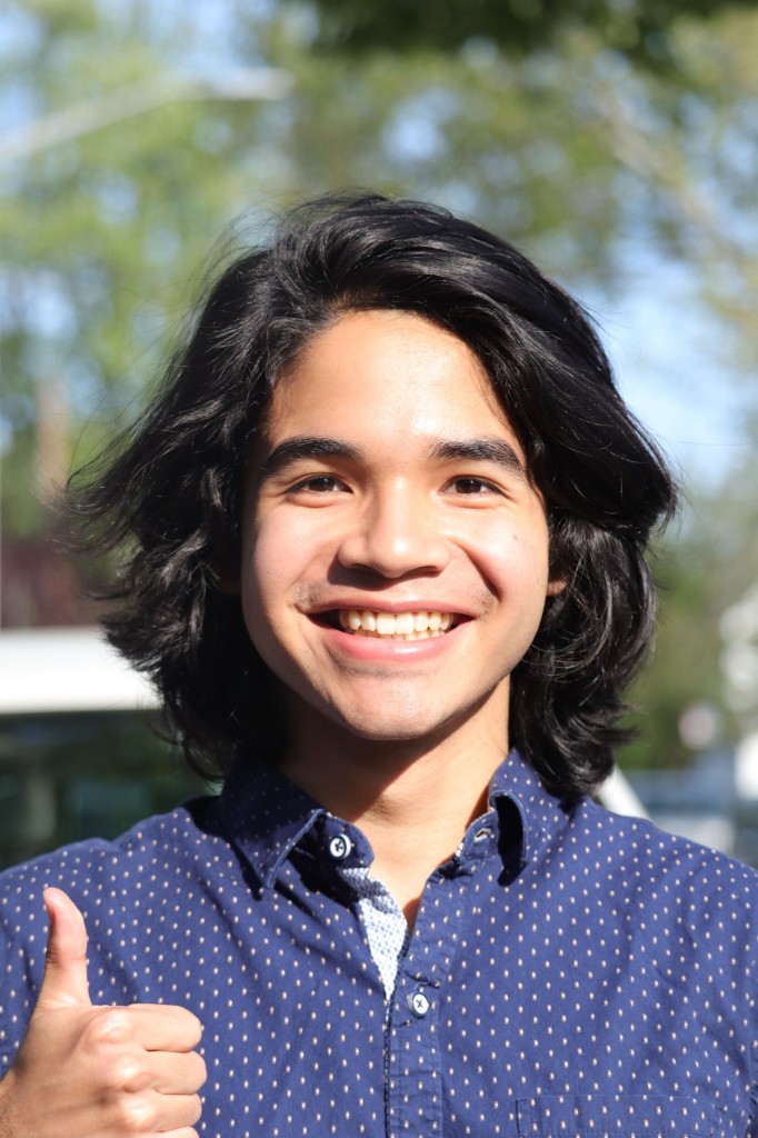 Portrait of Matthew Ham, HackBU President, smiling and giving a thumbs up outdoors in a navy polka-dot shirt.