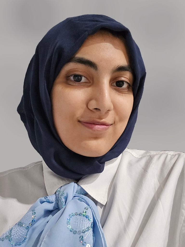 Portrait of Rijaa Zaidi, HackBU organizer, smiling in a navy headscarf and white collared shirt with a light blue scarf.