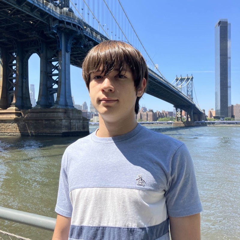 Portrait of Zak Sujkovic, HackBU organizer, standing by the East River beneath the Manhattan Bridge.